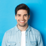 Free-Photo-Close-up-of-young-successful-man-smiling-at-camera-standing-in-casual-outfit-against-blue-background